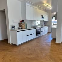 Completed white fitted kitchen with herringbone floor